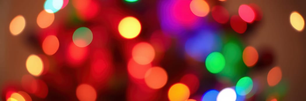 Bright, multicolored lights twinkle in a warm indoor environment, adding a delightful holiday spirit to the atmosphere during a winter celebration.