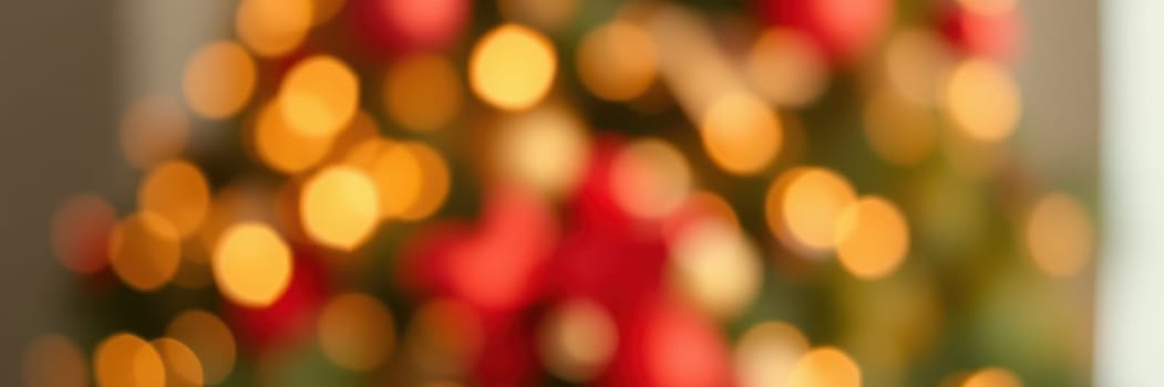 Softly glowing lights and vibrant red ornaments blur together, creating a joyful holiday atmosphere in a cozy indoor space filled with warmth.