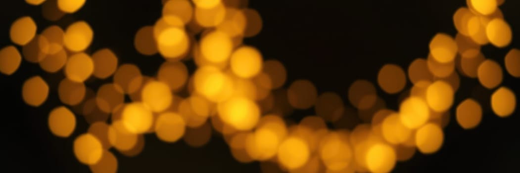Glowing golden bokeh lights fill the dark background, adding a warm and festive vibe to the evening event, enhancing the celebratory mood of the gathering.