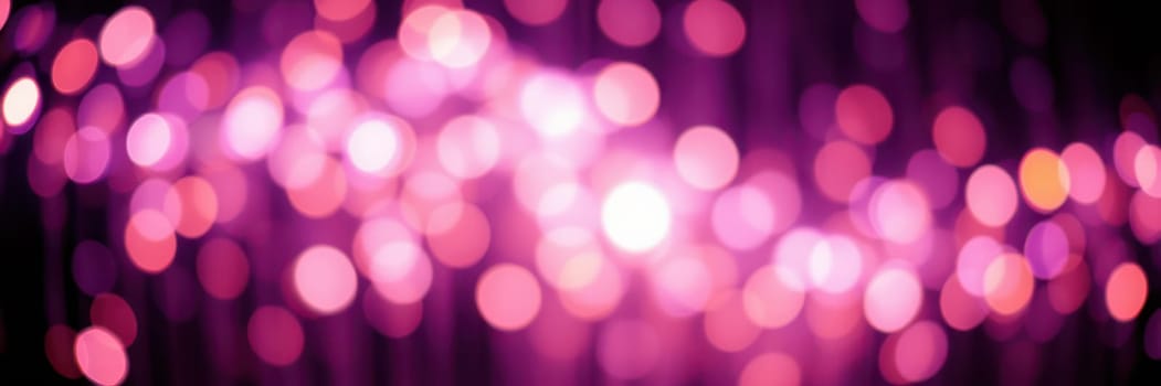 Bright, colorful lights blend together in a mix of pink and purple hues, creating a lively and festive atmosphere indicative of an evening celebration in the city.