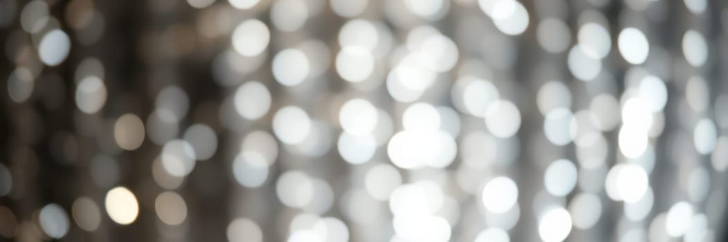 Soft, shimmering lights form a beautiful bokeh effect, enhancing the ambiance of a festive gathering. The setting is warm and inviting, perfect for celebrating with friends.