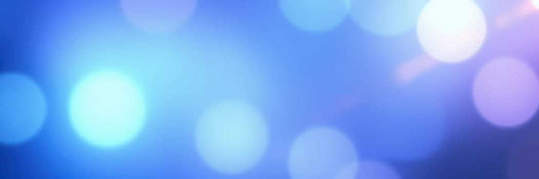 Soft, luminous bokeh lights in various shades of blue blend together, creating an enchanting backdrop. This colorful display adds warmth and charm to the evening ambiance.