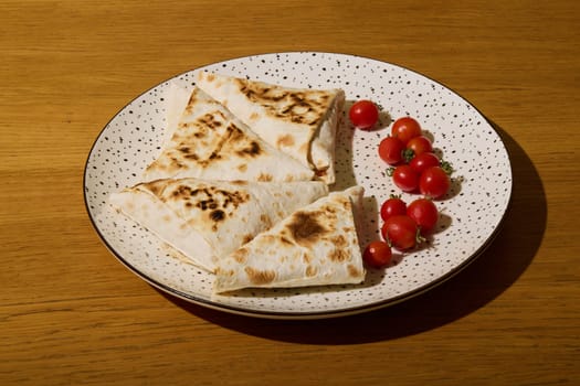 Goldenbrown grilled flatbreads accompanied by vibrant, fresh cherry tomatoes elegantly arranged on a stylish plate