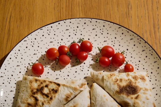 Indulge in the delight of delicious grilled flatbread, beautifully paired with fresh cherry tomatoes on a rustic plate
