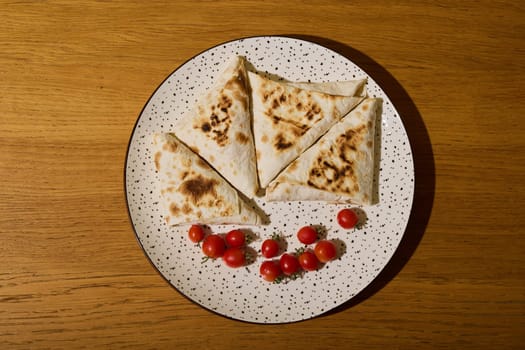 A plate of crispy pancakes with vibrant cherry tomatoes, perfect for breakfast or delightful snacks
