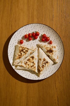 A beautiful plate of golden flatbreads topped with fresh cherry tomatoes, perfect for delightful snacking