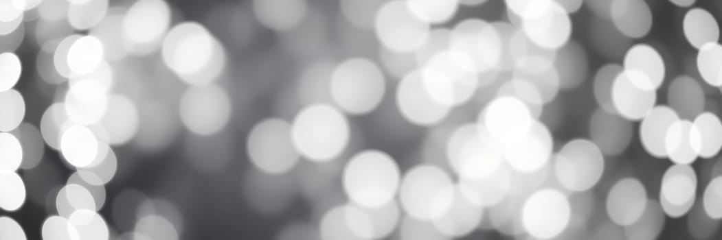 Soft, blurred lights in a monochromatic palette create a captivating bokeh effect, perfect for enhancing the ambiance of any event or design project.