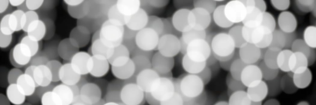 Delicate, blurred lights twinkle softly against a dark background, creating a magical ambiance perfect for evening festivities in an urban environment.