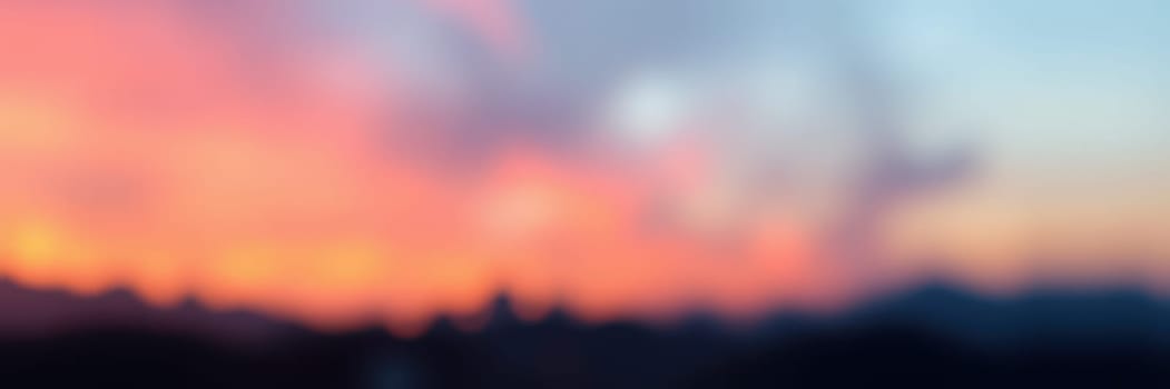 A stunning sunset unfolds with vibrant colors blending in the sky above a mountainous horizon. The atmosphere is peaceful, evoking a sense of tranquility at dusk.
