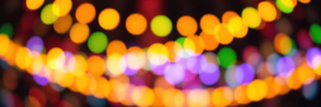 Colorful bokeh lights illuminate the space, enhancing the festive mood. Various hues blend together, creating a magical nighttime ambiance perfect for social gatherings.