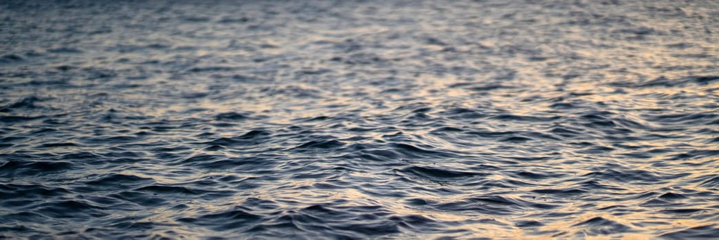 View of water surface with small ripples, waves, seascape without people, wildlife with endless blue ocean closeup.