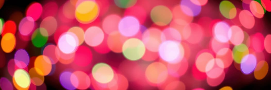 A multitude of colorful lights fills the background, creating a lively atmosphere. These bokeh effects suggest a joyous celebration, typical of nighttime events.