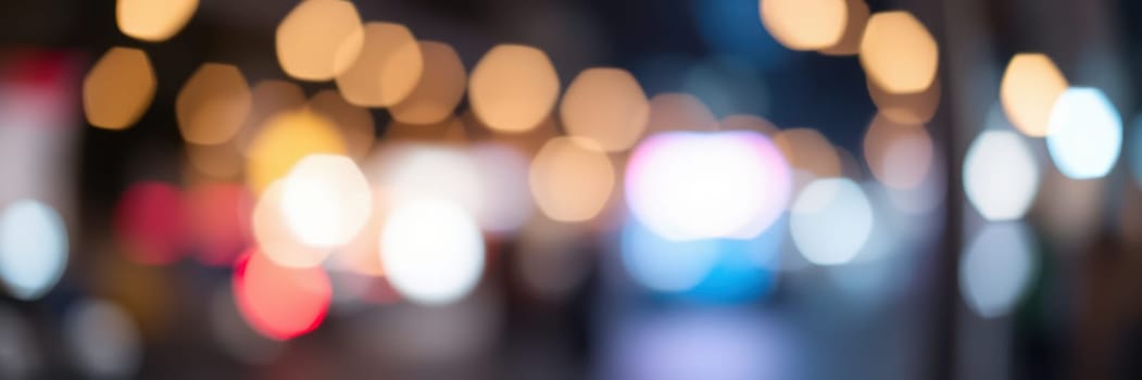 Colorful lights illuminate a busy street, creating a lively atmosphere. Various shapes and colors blend together, reflecting the energy of the city at night.