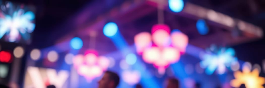 Brightly colored lights illuminate a crowded indoor venue. People enjoy dancing and socializing amidst a festive atmosphere created by dynamic lighting and music.