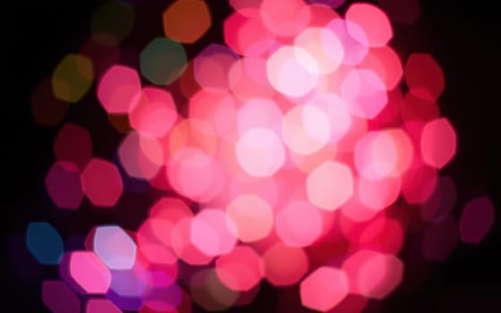 A stunning array of colorful bokeh lights fills the background during a night festival, illuminating the city square with a joyful ambiance for attendees to enjoy.
