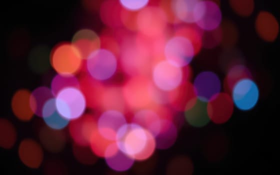 A blur of colorful bokeh lights fills the frame, creating a lively and festive ambiance. These lights twinkle in various hues, enhancing the nighttime celebration atmosphere.