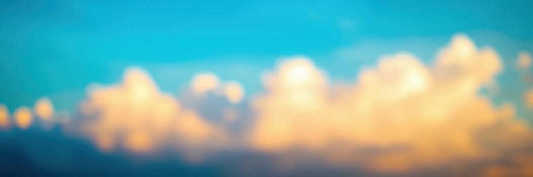 Soft clouds glow with warm hues during sunset, creating a tranquil atmosphere against the backdrop of a clear blue sky in the evening.