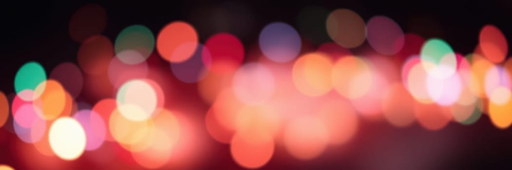 Various vibrant bokeh lights blur together, enhancing the festive ambiance of a nighttime celebration in an urban environment filled with joy.