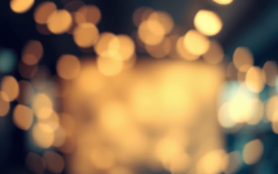 Soft, blurred lights illuminate an indoor space, creating a warm and inviting ambiance. The warm glow suggests a relaxed evening atmosphere perfect for gatherings.