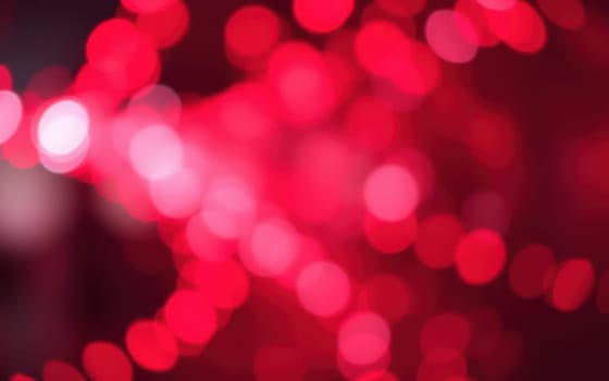 A vibrant array of red bokeh lights fills the background, creating an energetic ambiance. The soft focus enhances the festive mood perfect for evening gatherings or celebrations.