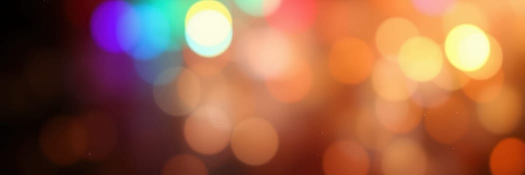 Bright, colorful lights softly blur together in a beautiful display, enhancing the ambiance of a festive gathering or celebration in the evening.