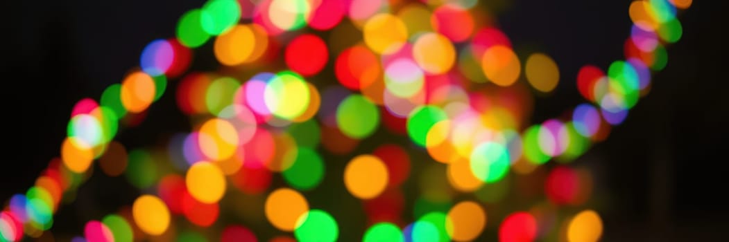 A beautifully decorated holiday tree sparkles with vibrant colored lights in a winter evening setting, evoking the joy of seasonal festivities and togetherness.