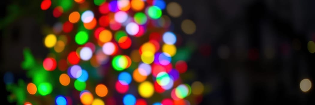Colorful lights sparkle in various hues, illuminating the surroundings. The ambiance is joyous, evoking the spirit of the holiday season as people gather and celebrate.