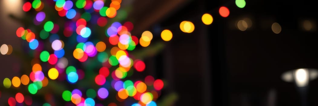 Bright and colorful lights adorn a Christmas tree, creating a warm and inviting atmosphere in a cozy indoor space filled with holiday cheer.