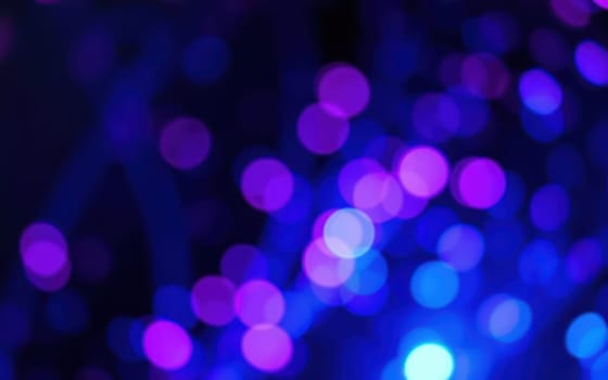A multitude of colorful bokeh lights fills the background, creating a lively and festive atmosphere during an outdoor evening event in the city.