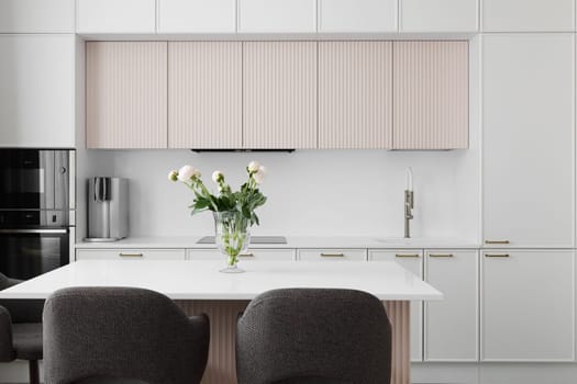 This stylish kitchen features elegant white cabinets and charming floral decor for a fresh, inviting look