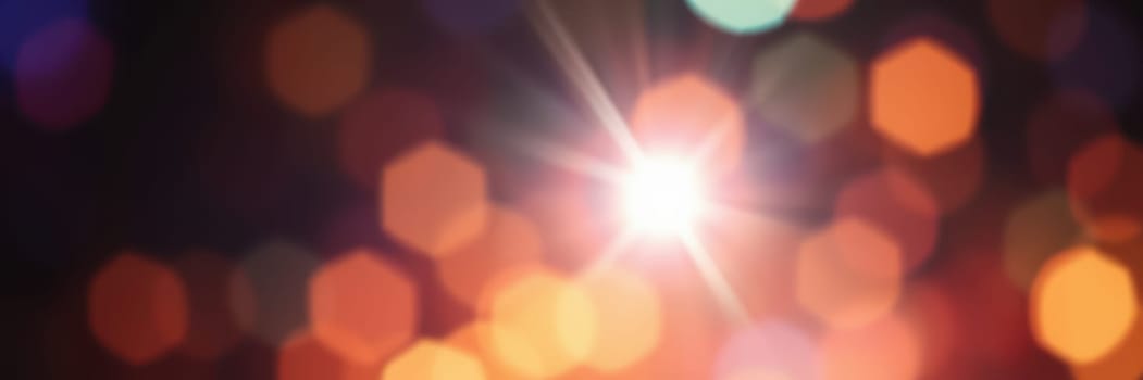 Bright, colorful lights create a bokeh effect, enhancing the ambiance of an evening event in an urban environment, reflecting warmth and energy around.