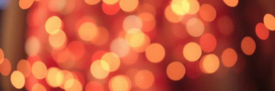 Warm orange and yellow bokeh lights illuminate the space, creating a cozy and inviting atmosphere perfect for a festive gathering. The soft, blurred effect enhances the celebratory mood.