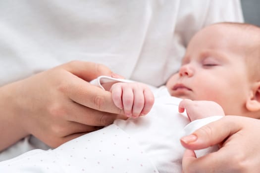 Close-up captures the heartwarming scene of a newborn baby's hand tenderly embracing mother's finger