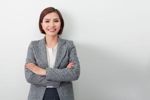 Asian successful confident young businesswoman with arms crossed isolated in white background