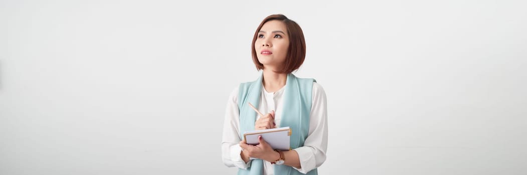 Beautiful young asian business woman holding clipboard over white banner background