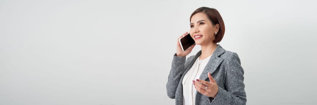 Young elegant woman talking on mobile phone against white banner background