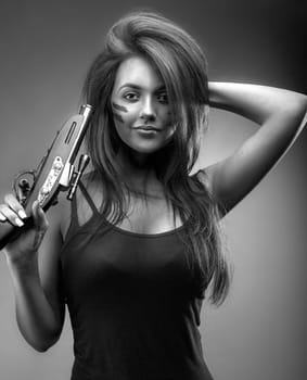 Girl with an old pistol in her hand. Monochrome