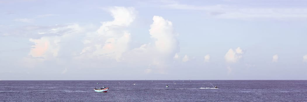 Sea sky cumulus cloud landscape view background. Calm water alone fishing boat. Destination aim progress concept.