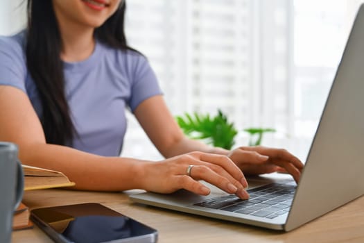 Select focus on woman hands typing on laptop keyboard, searching information, working or working online.