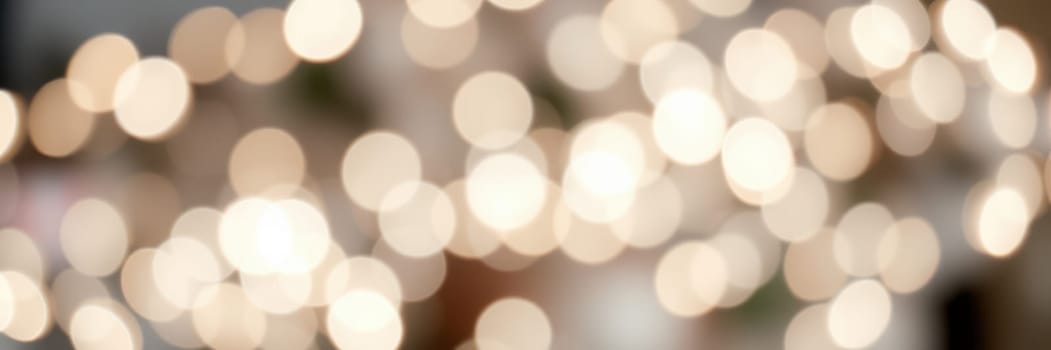 A variety of soft, warm lights illuminate an indoor space, creating a cozy and inviting ambiance. The blurred lights suggest a relaxed atmosphere ideal for socializing or celebrating.