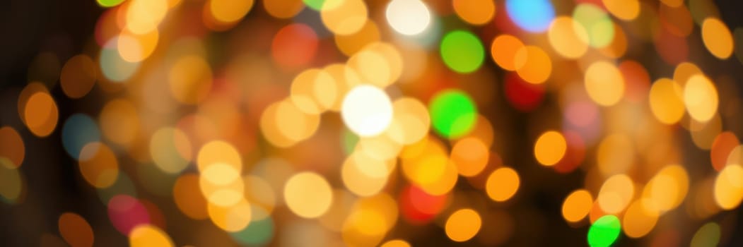 Vibrant lights in various colors illuminate the night sky, creating a joyous ambiance perfect for a celebration. People gather and enjoy the festive mood.