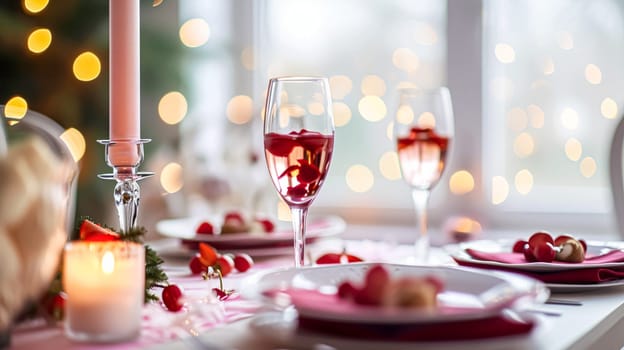 Festive table setting with candles and arrangement of beautiful red flowers. Holiday concept. High quality photo