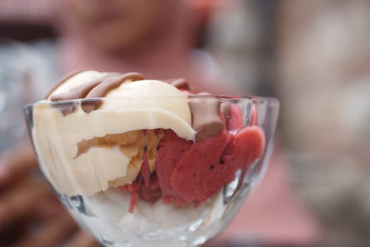 A beautifully vibrant ice cream sundae, featuring rich flavors and an array of toppings
