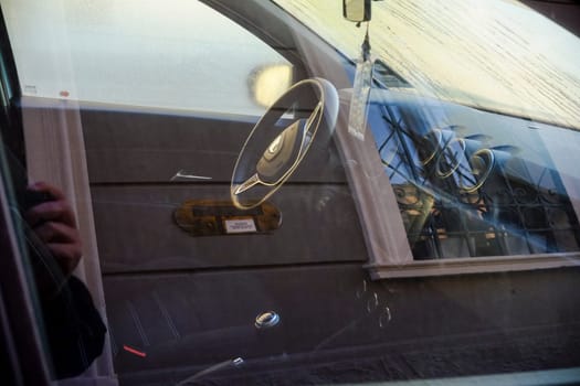 Cremona, Itally - October 6th 2024 Interior perspective of a stationary geely emgrand ec7 rv with a reflection of a building facade, highlighting the steering wheel and dashboard features