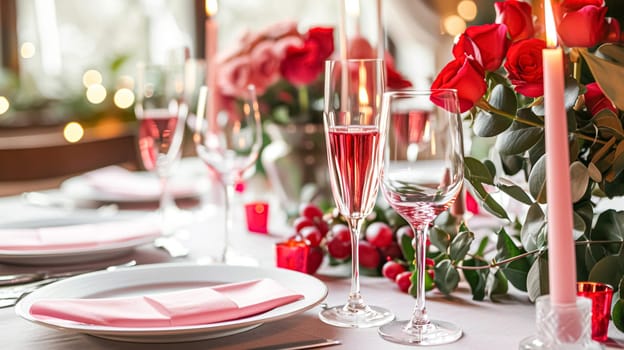 Festive table setting with candles and arrangement of beautiful red flowers. Holiday concept. High quality photo