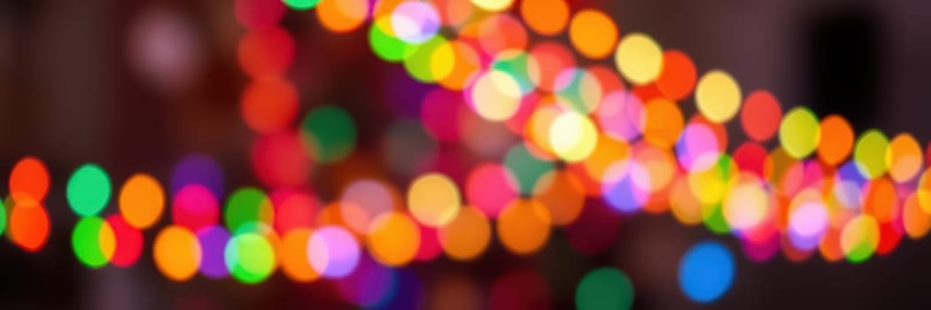 Brightly colored lights illuminate the surroundings, creating a lively and joyful ambiance. The atmosphere is filled with excitement and celebration during the evening festivities.