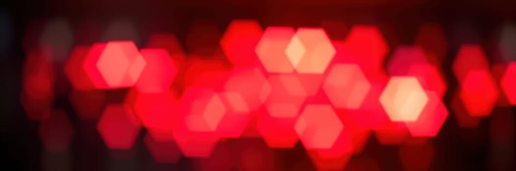 A series of bright red lights illuminate a dark space, creating a dynamic and energetic ambiance for an evening event. The vibrant glow enhances the excitement and mood.