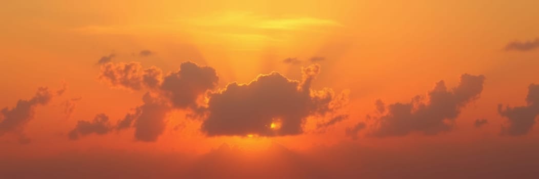 A stunning sunset unfolds over the ocean, with golden clouds illuminated by the warm light. Rays of sunlight pierce through the clouds, creating a tranquil atmosphere.