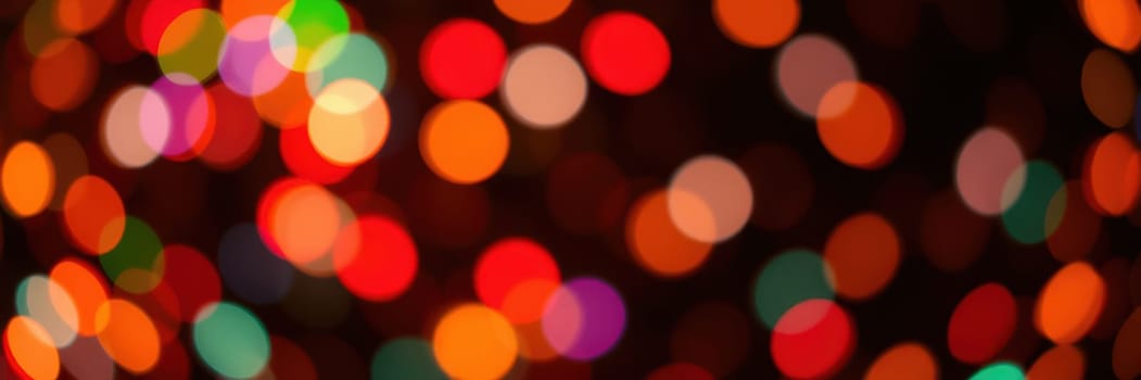 Bright and colorful lights blur into vibrant circles, filling the night with a warm and joyful ambiance. The scene evokes a sense of celebration and holiday spirit in the city.