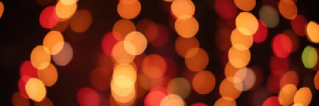 Strands of glowing lights in warm hues create a vibrant, festive atmosphere during a night celebration in a lively city environment, inviting joy and wonder.